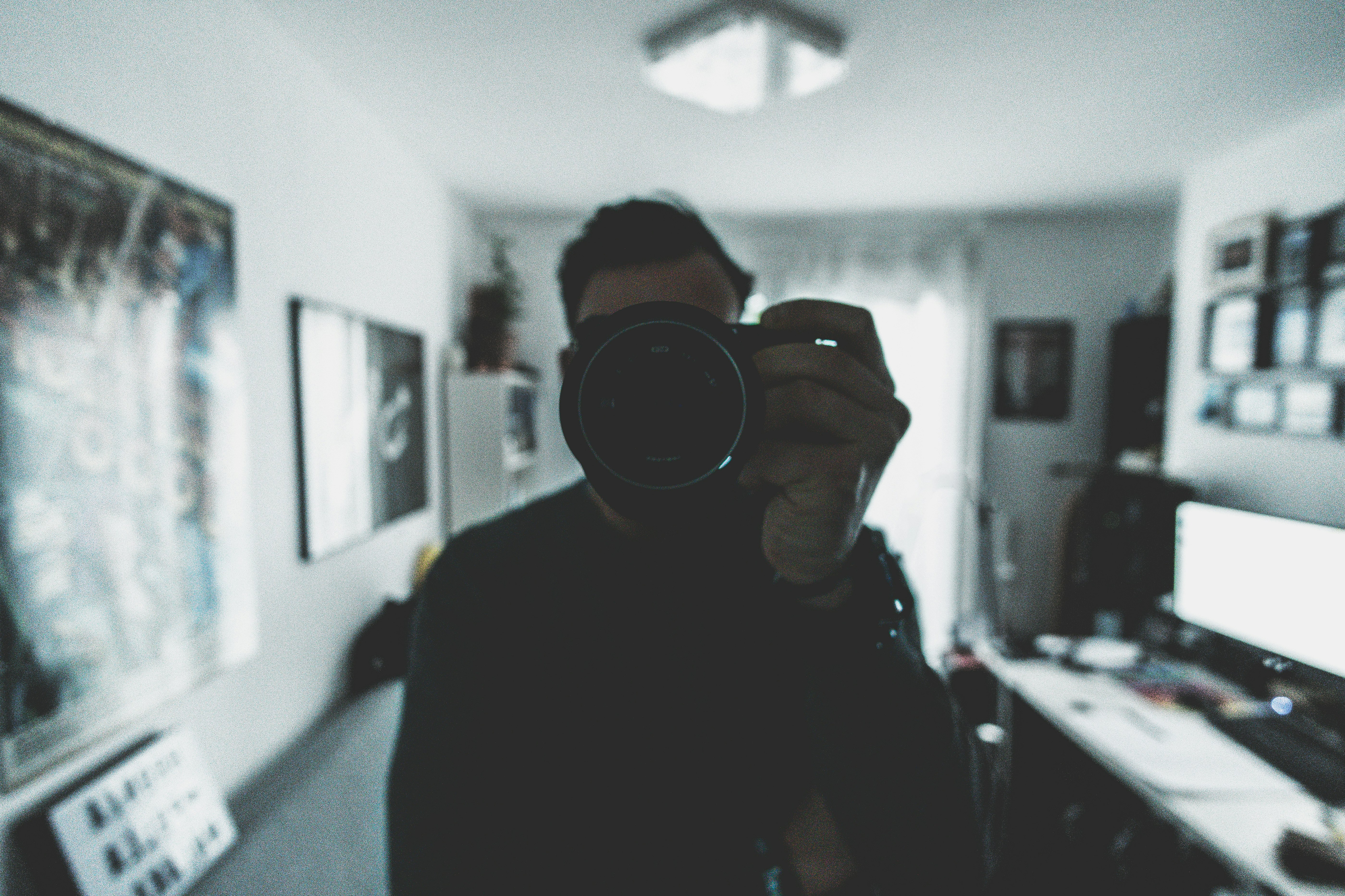 person holding camera inside white painted room